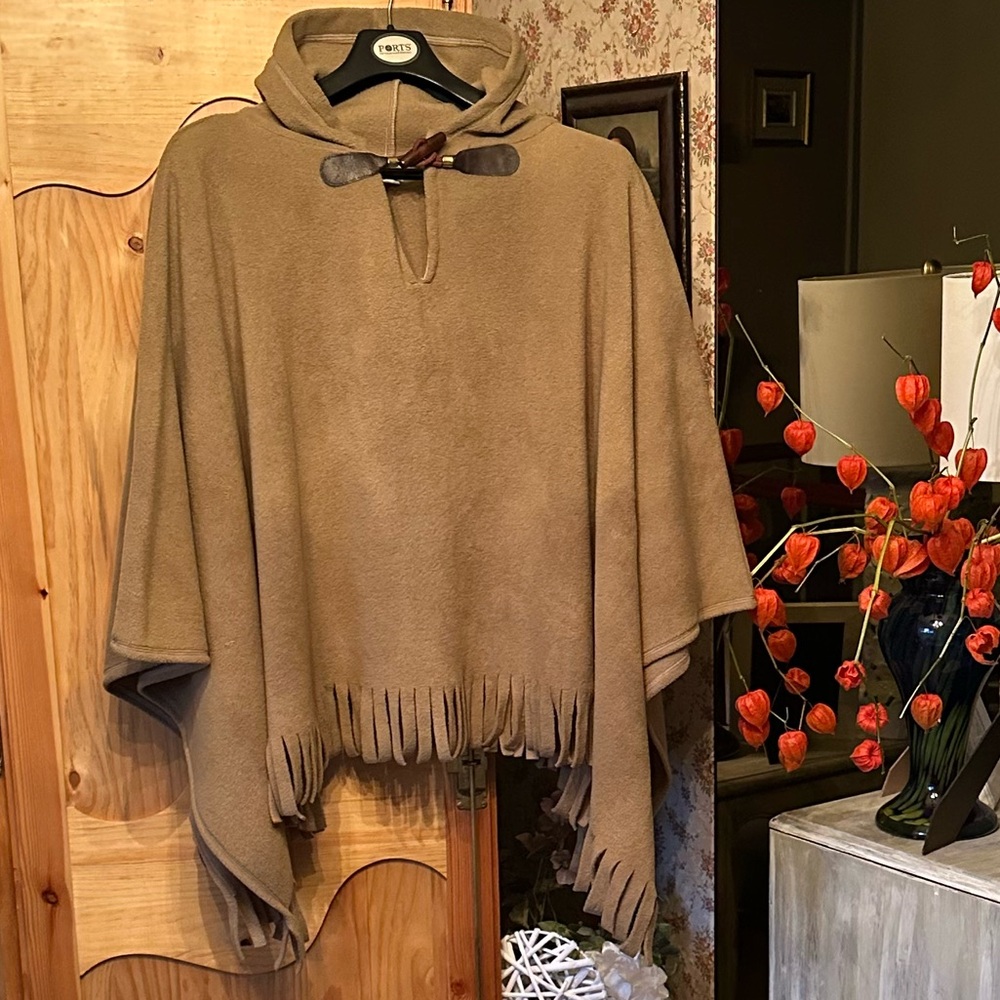 Fringed cape in tan with hood and big button closure. 27 inches/68.58 long $50